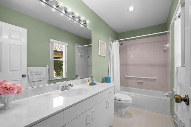 a bathroom with a granite countertop sink a toilet and shower