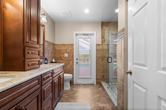 a bathroom with a granite countertop sink a mirror and a shower