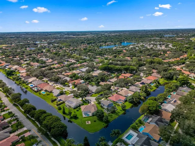 an aerial view of residential houses with outdoor space and trees