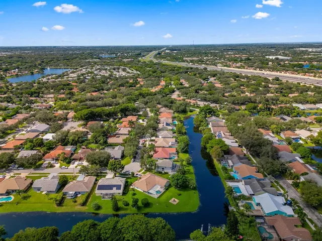 an aerial view of residential houses with outdoor space and trees
