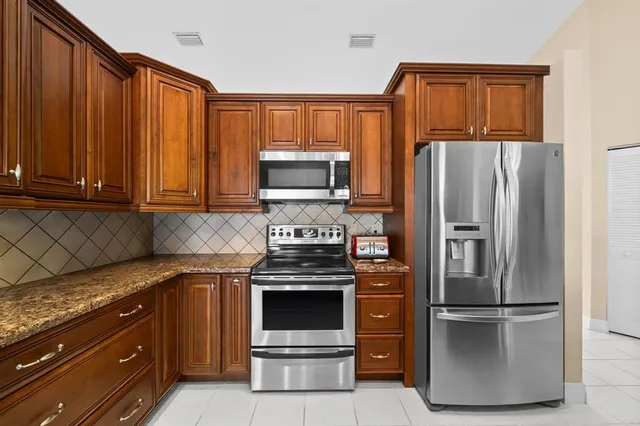a kitchen with appliances a refrigerator and a window