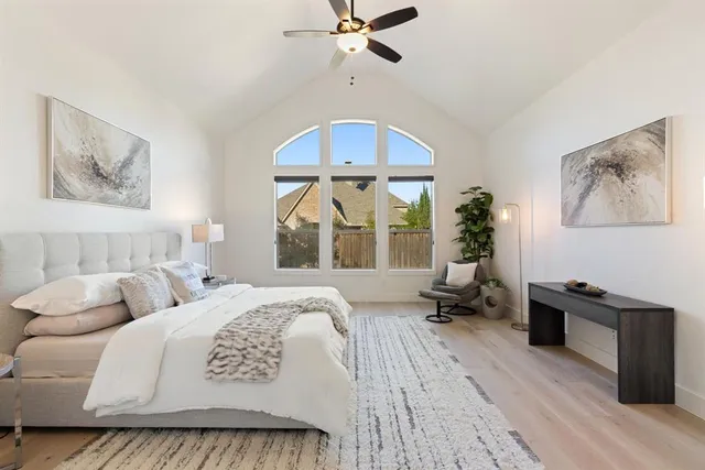 a spacious bedroom with a bed a couch and a chandelier