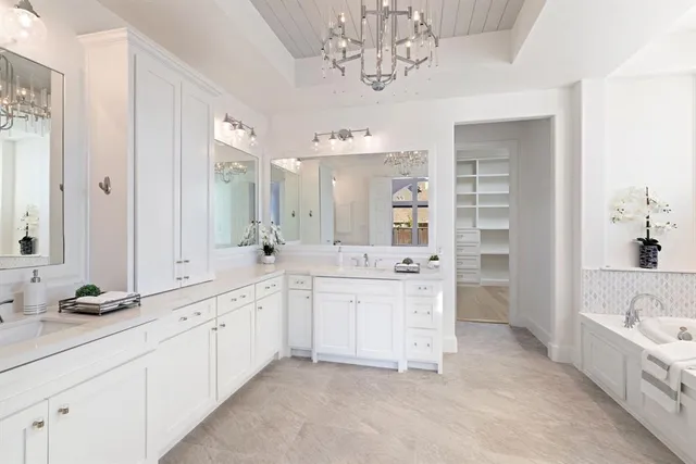 a large bathroom with a double vanity sink a mirror a bathtub and