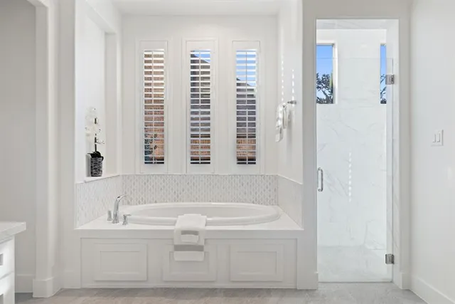 a bathroom with bathtub and window