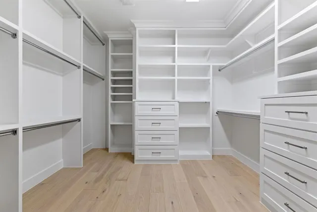 a view of walk in closet with empty racks