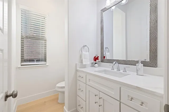 a kitchen with white cabinets and window