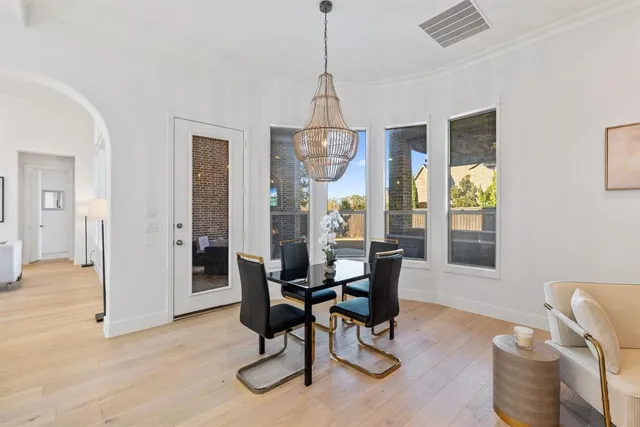 a dining room with furniture a chandelier and wooden floor