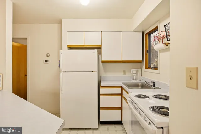 a kitchen with a refrigerator sink stove and white cabinets