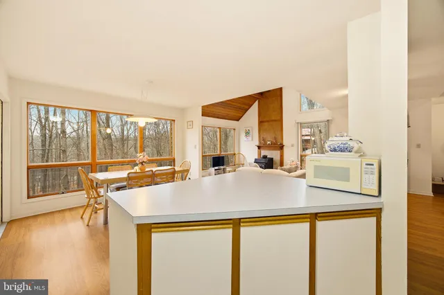 a living room with a large window and kitchen view
