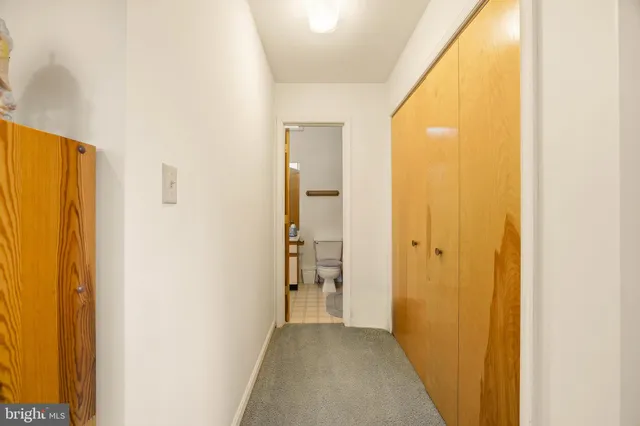 a view of a hallway with wooden shelves