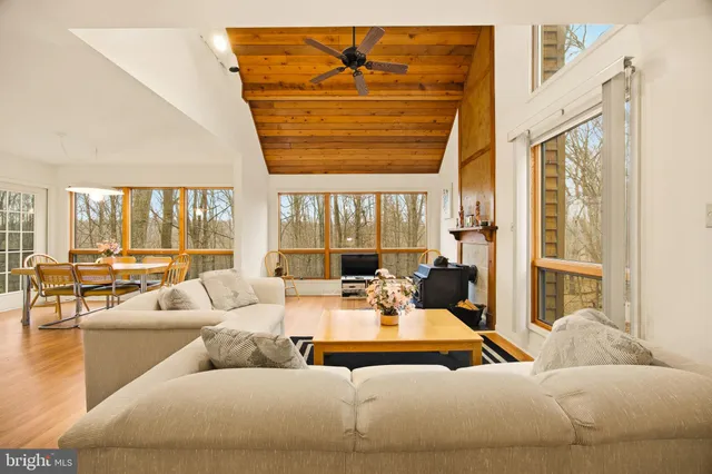 a living room with furniture and floor to ceiling windows
