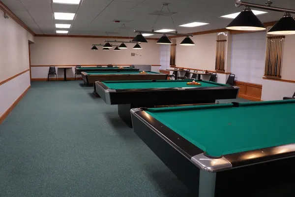 a room with pool table and windows