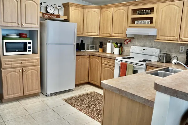 a kitchen with a refrigerator sink stove and cabinets