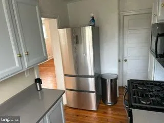 a kitchen with stainless steel appliances a refrigerator and wooden floor