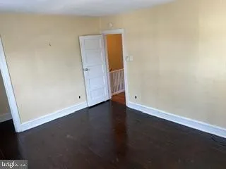 an empty room with wooden floor and cabinet