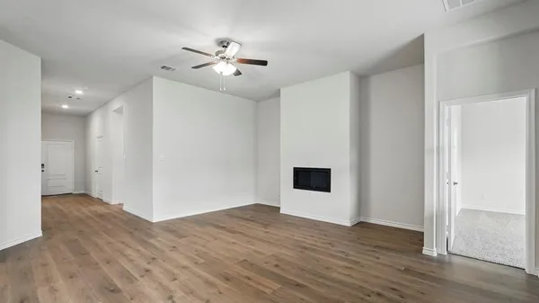 a view of an empty room with wooden floor