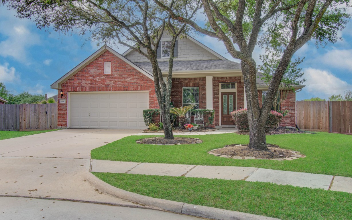 20007 Alcea Court Spring, TX 77379 - Photo 2 of 43 This charming brick home features a two-car garage and a welcoming front porch. Nestled on a well-maintained lawn with mature trees, it offers a spacious driveway and a sense of privacy with a fenced backyard. Ideal for comfortable family living.