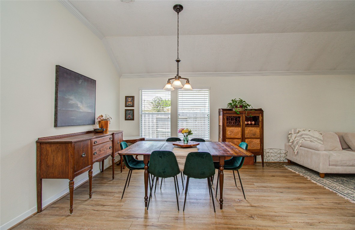 20007 Alcea Court Spring, TX 77379 - Photo 9 of 43 Bright dining area with a wooden table, elegant chairs, and classic furniture. Features high ceilings, light wood flooring, and ample natural light from large windows. Cozy, inviting atmosphere ideal for gatherings.