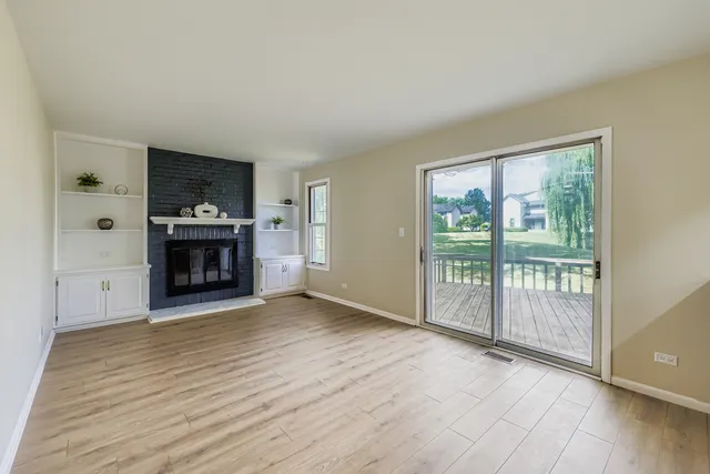 wooden floor fireplace and windows in an empty room