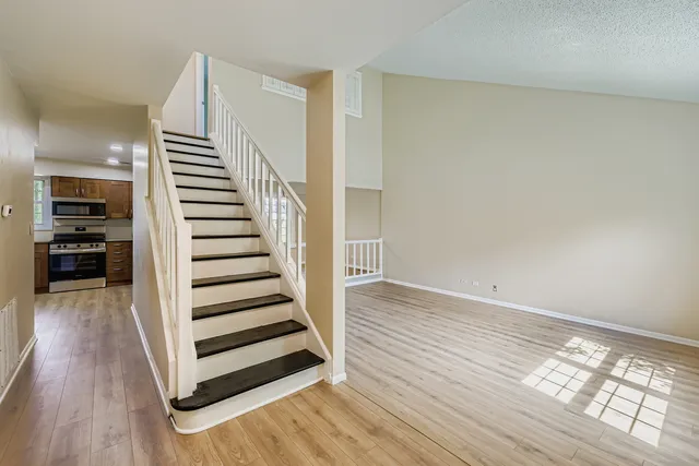 a view of a room with wooden floor and stairs