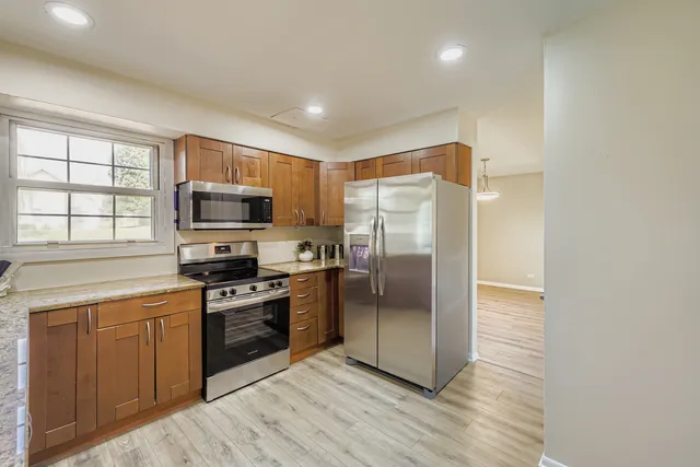 a kitchen with stainless steel appliances a refrigerator a stove top oven a sink and dishwasher
