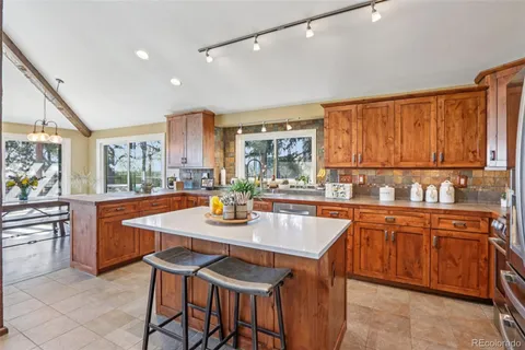 a kitchen with stainless steel appliances granite countertop a stove a sink and a refrigerator