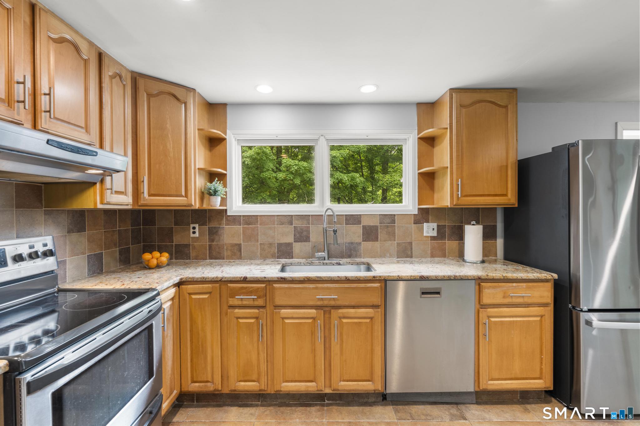 200 Old Huckleberry Road Wilton, CT 06897 - Photo 8 of 24 a kitchen with stainless steel appliances granite countertop a sink stove and refrigerator