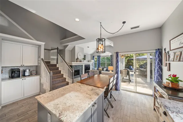 a dining room with wooden floor a glass table and chairs