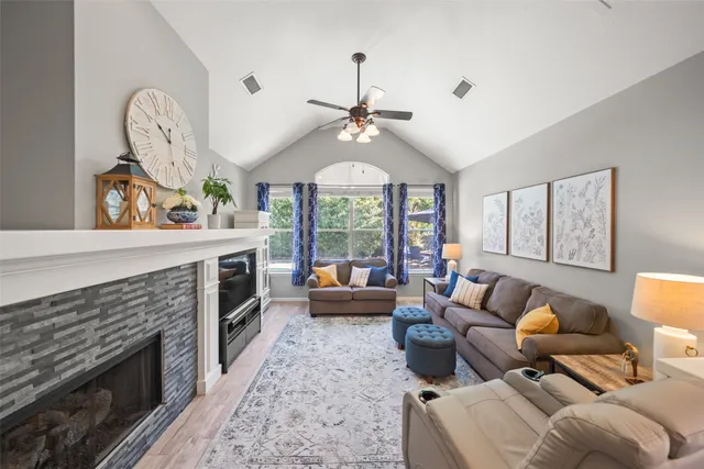 a living room with furniture a fireplace and a large window
