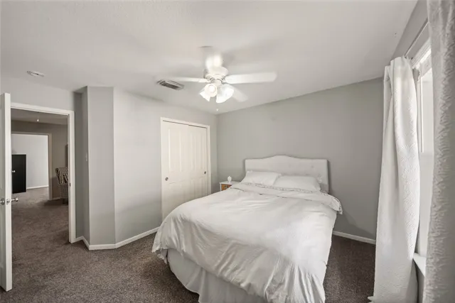 a bedroom with a bed and a ceiling fan