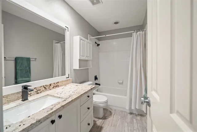 a bathroom with a granite countertop sink toilet and shower