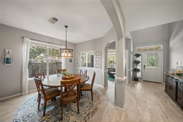 a dining room with furniture wooden floor a chandelier