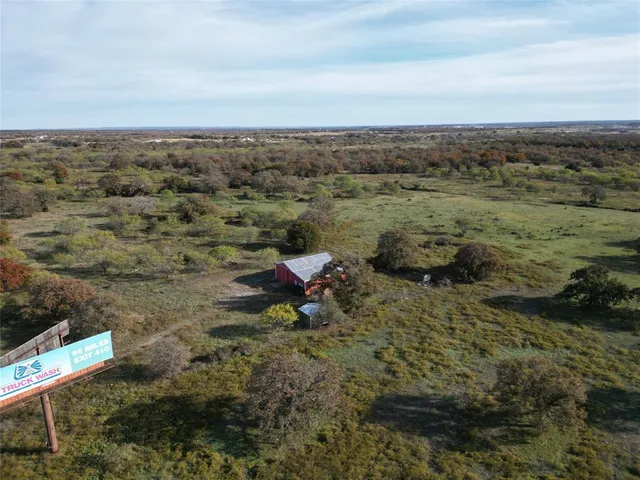 a view of a dry yard with wooden fence
