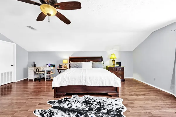 a bedroom with bed and wooden floor