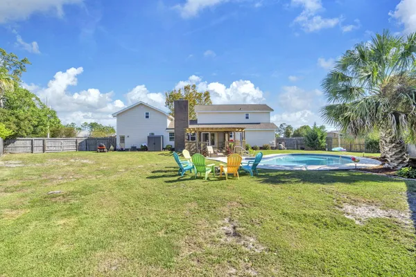 a swimming pool with outdoor seating and yard