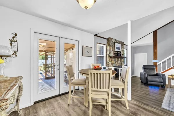a living room with couches and kitchen view with wooden floor