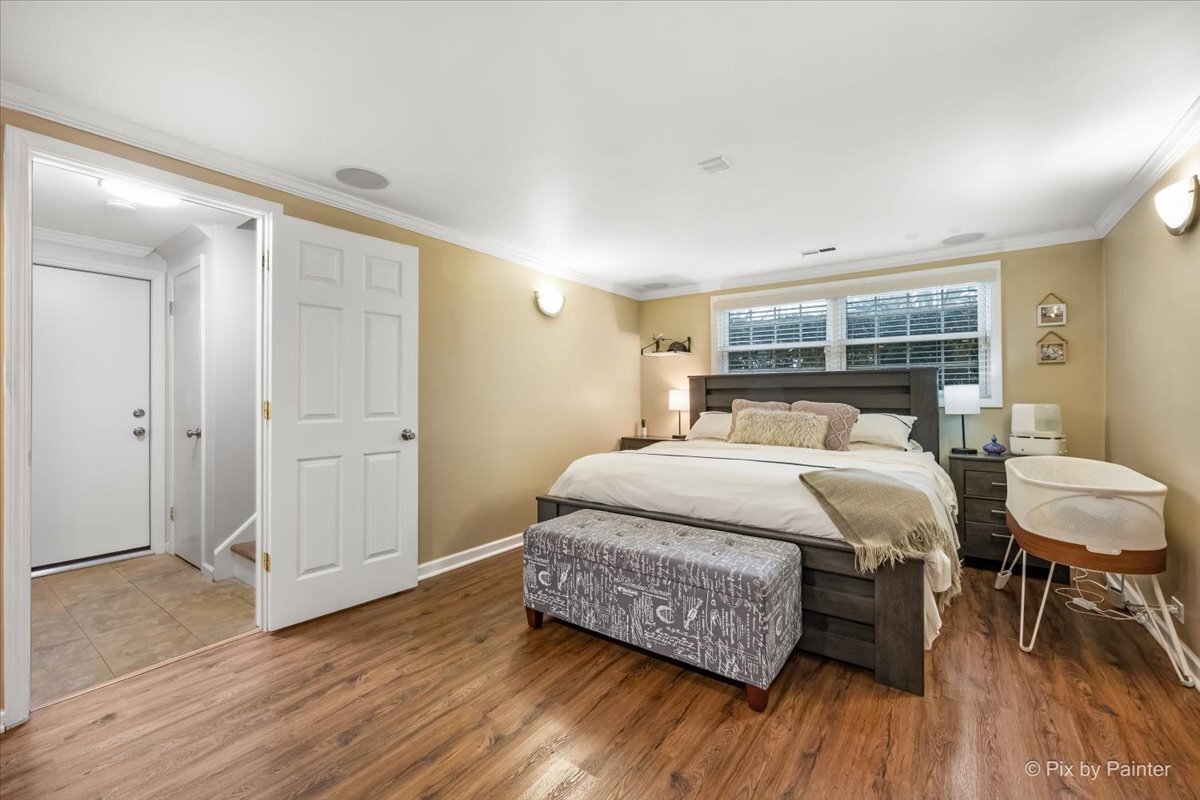 647 North Ridgemoor Avenue Mundelein, IL 60060 - Photo 15 of 39 a bedroom with a bed a table and wooden floor