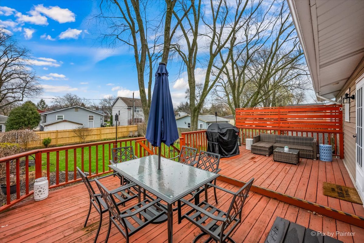 647 North Ridgemoor Avenue Mundelein, IL 60060 - Photo 26 of 39 a view of a patio with table and chairs under an umbrella with wooden floor