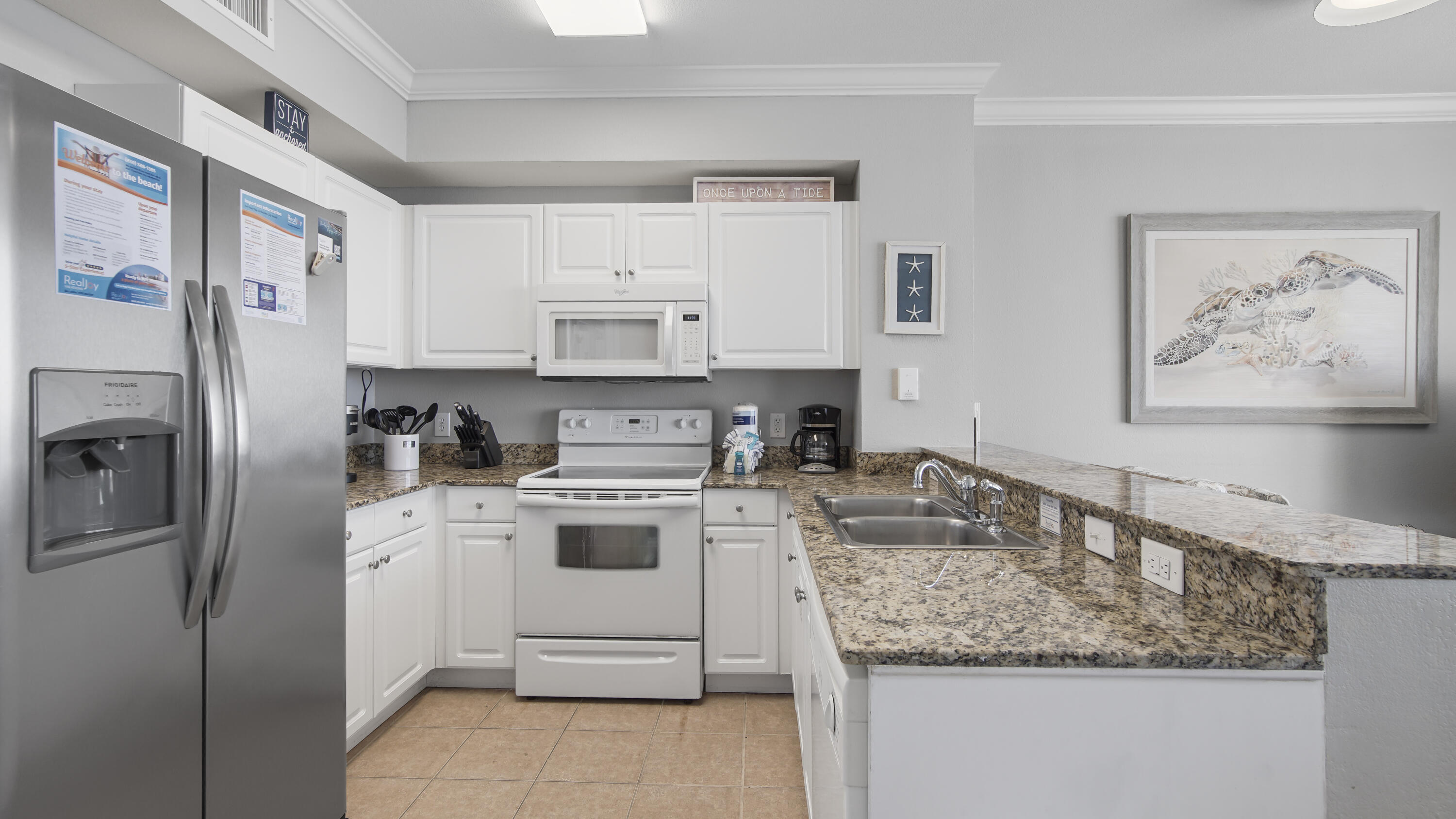 16819 Front Beach Road, Unit 1810 Panama City Beach, FL 32413 - Photo 38 of 54 a kitchen with stainless steel appliances granite countertop a sink stove and refrigerator
