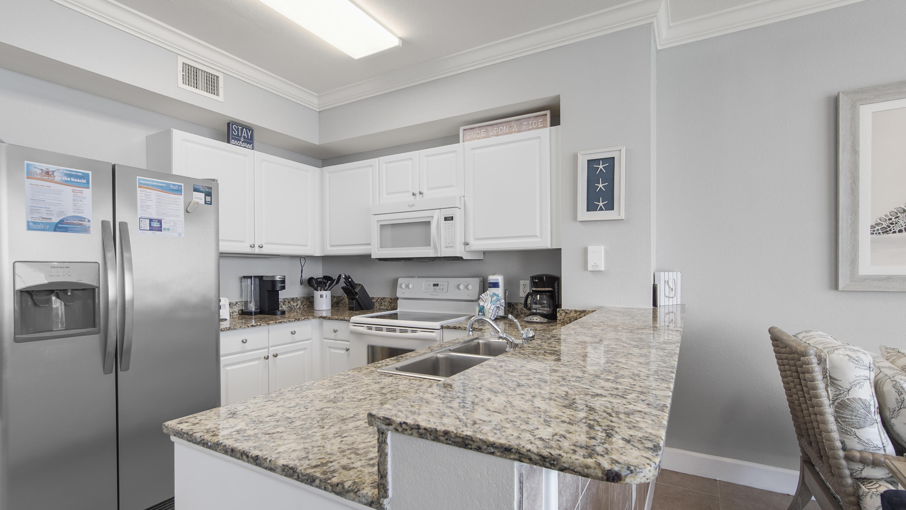 16819 Front Beach Road, Unit 1810 Panama City Beach, FL 32413 - Photo 41 of 54 a kitchen with stainless steel appliances granite countertop a sink stove and refrigerator