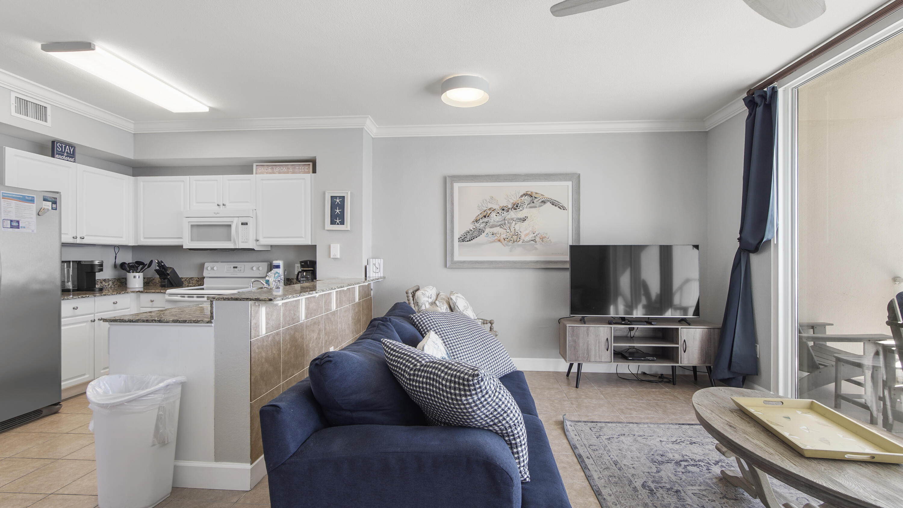 16819 Front Beach Road, Unit 1810 Panama City Beach, FL 32413 - Photo 42 of 54 a living room with furniture a kitchen view and a refrigerator