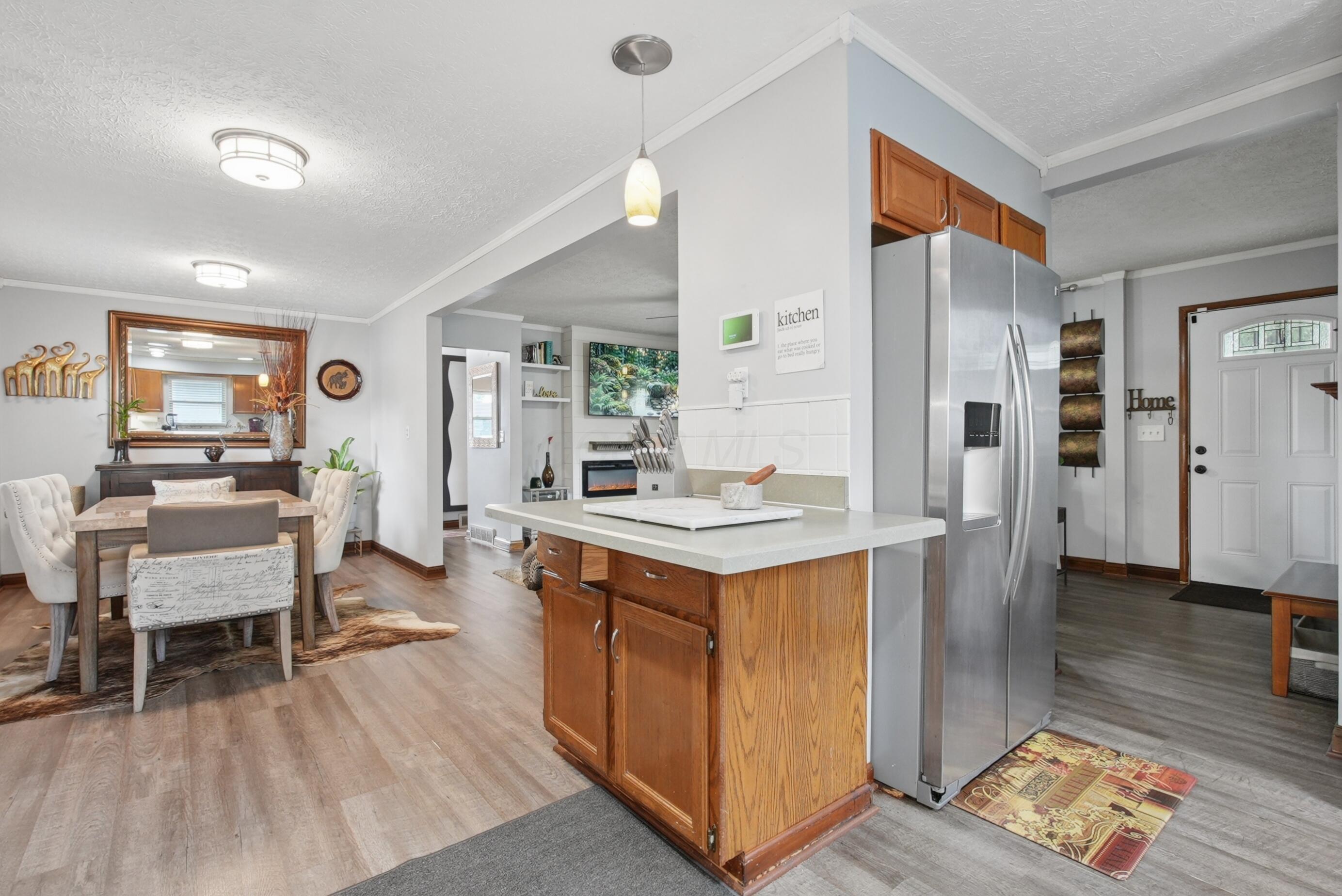 Kitchen island with cabinet storage, stainless steel refrigerator.