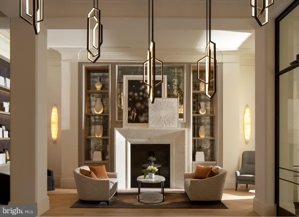 a living room with furniture a fireplace and a chandelier