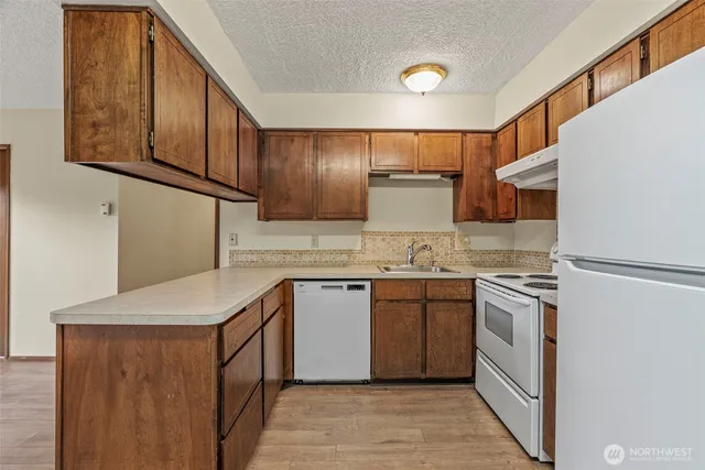 a kitchen with granite countertop a stove and a wooden floors