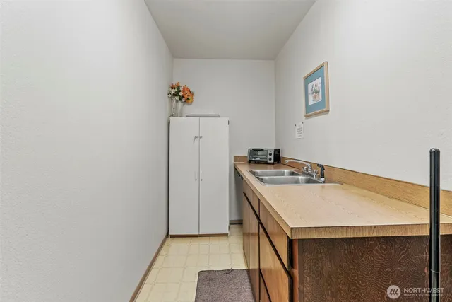 a view of a hallway with entryway a chandelier and a refrigerator