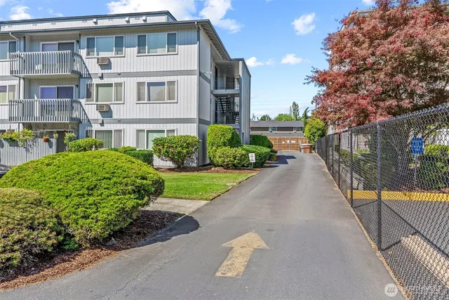 a front view of a house with a yard and potted plants