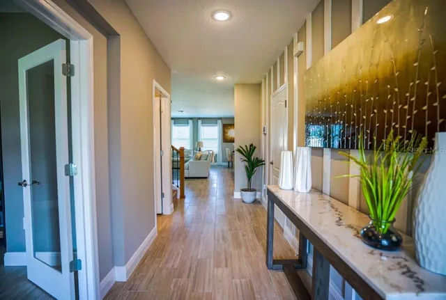 a view of a hallway view with wooden floor and a potted plant