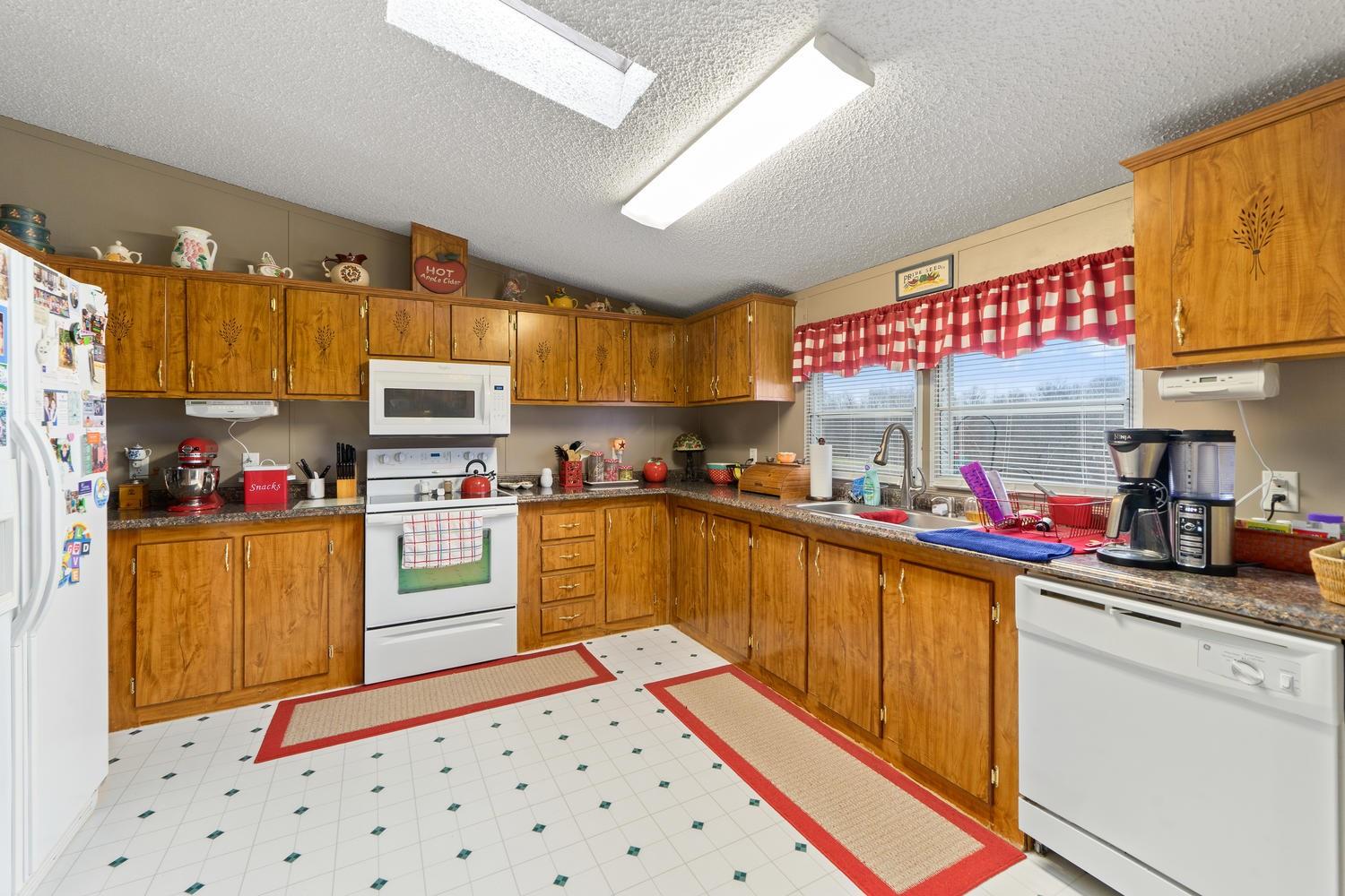 2448 Graham Cemetery Road Clarksville, TN 37043 - Photo 7 of 24 a kitchen with stainless steel appliances a sink a stove top oven a counter space and cabinets