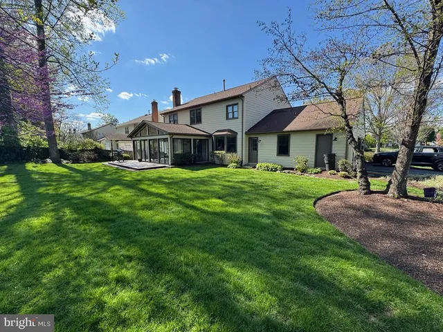 a front view of a house with garden and trees