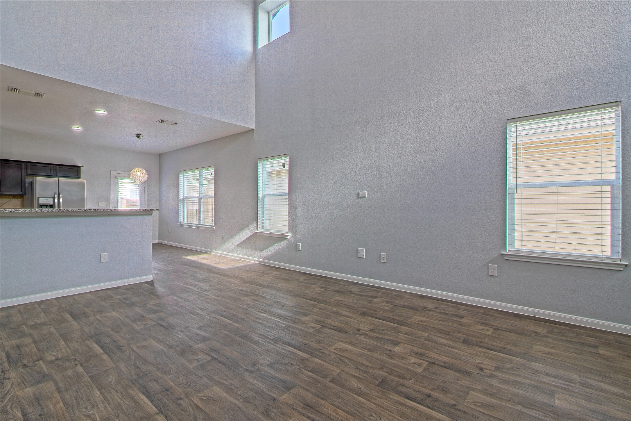 3408 Tilmon Ln. Austin, TX 78725 - Photo 7 of 35 Unfurnished living room featuring a high ceiling and dark wood-style floors